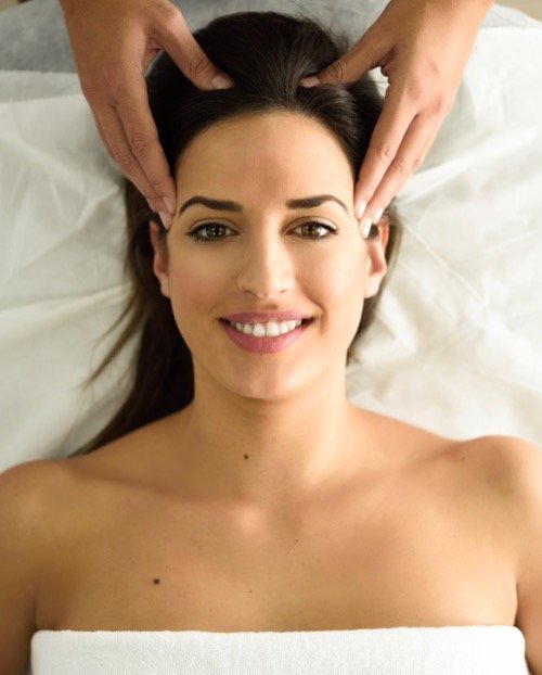 young smiling woman receiving a head massage in a XTDCZR7